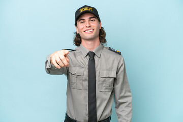 Young safeguard man isolated on blue background points finger at you with a confident expression