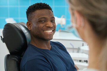 African American man smiling to camera showing healthy white teeth