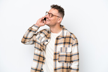 Young caucasian handsome man isolated on white background keeping a conversation with the mobile phone