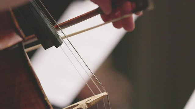 Slow motion video of a musician playing an acoustic cello with a bow during a performance. Nr.3