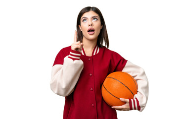 Young Russian woman playing basketball over isolated chroma key background thinking an idea pointing the finger up