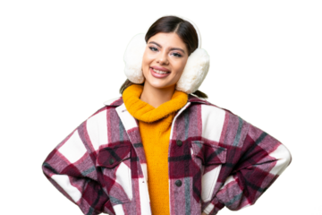 Young Russian woman wearing winter muffs over isolated chroma key background posing with arms at hip and smiling