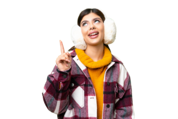 Young Russian woman wearing winter muffs over isolated chroma key background pointing up and surprised
