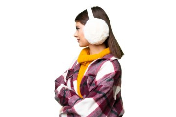 Young Russian woman wearing winter muffs over isolated chroma key background in lateral position
