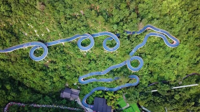 Top View of Kart Race Track in Amusement Park, Tonglu, China. Race car circuit on a sunny day. Kart racing field with dense trees. Karting racing sport concept shot.