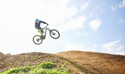 Fototapeta premium Mountain bike, man and jump in sky for competition, freedom and off road adventure. Athlete, extreme sports and bicycle in air for action, cardio race and stunt power in nature, path and mockup space