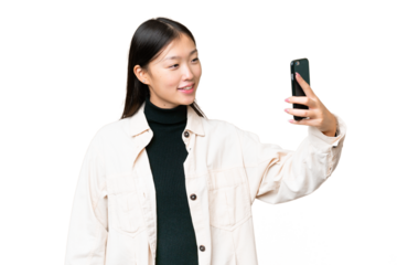 Young Asian woman over isolated chroma key background making a selfie
