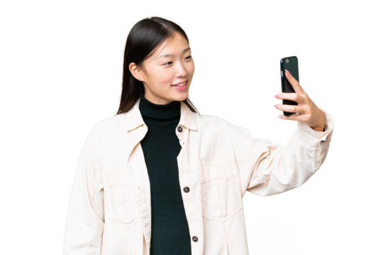 Young Asian woman over isolated chroma key background making a selfie