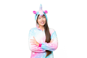 Young Asian woman with unicorn pajamas over isolated chroma key background looking up while smiling
