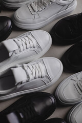 Six pairs of black and white sneakers on the floor. Casual fashion style minimalistic shoes.