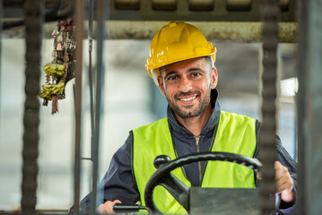 Portrait of forklift truck driver man smiling in old factory warehouse lifting pallet in storage shipping. forklift truck driver mail inside old forklift smiling to worker employee in warehouse store. - obrazy, fototapety, plakaty