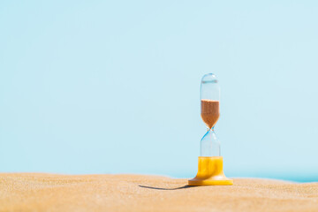 Sand running through an old hourglass measuring passing time and counting down to a deadline