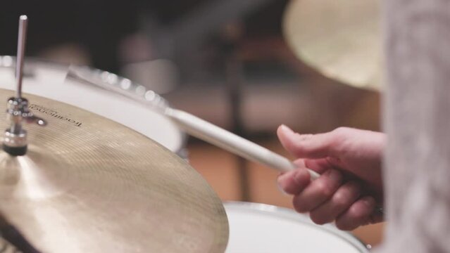 Slow motion video of a drummer playing the cymbals of their drumset with steel brush sticks. Nr.2