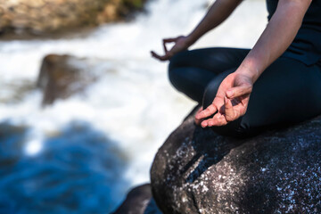 Close up lotus yoga pose on the rocks near river