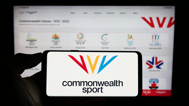 Stuttgart, Germany - 07-30-2023: Person holding mobile phone with logo of organisation Commonwealth Games Federation (CGF) on screen in front of web page. Focus on phone display.