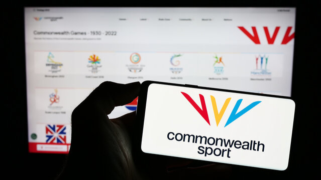 Stuttgart, Germany - 07-30-2023: Person holding cellphone with logo of organisation Commonwealth Games Federation (CGF) on screen in front of webpage. Focus on phone display.