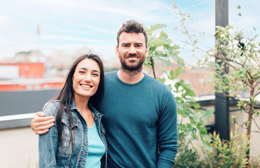 portrait of young couple in the terrace of their apartment