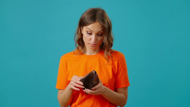 Frustrated poor woman throws away empty wallet shaking head