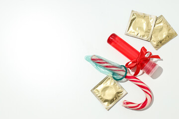 Lubricant in a red bottle with a bow, condoms and candy, place for text