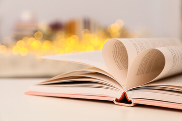 Heart from book pages on light background