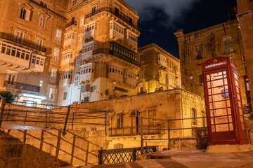 the empty streets of Valletta at night. Street lights illuminate the old houses