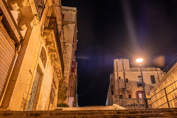 the empty streets of Valletta at night. Street lights illuminate the old houses