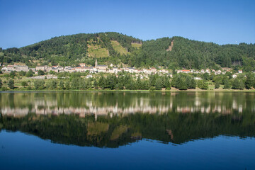 Le village de Saint-Martial (Ardèche) se reflétant dans un lac artificiel