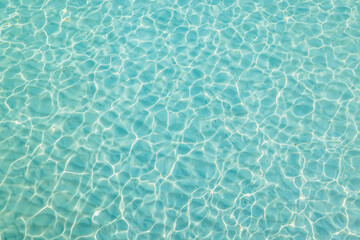Water in swimming pool. Bright rippled water surface detail background. Tranquil tropical...