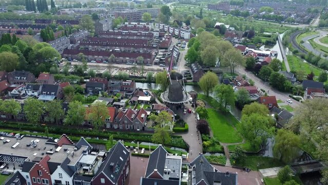 Small town in the Netherlands. Traditional windmill. People commute.
