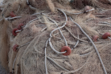 Beautiful bitonal photography with ivory colors for the very fine net and for the rope and very desaturated red for the floats. In focus the closest part of the photograph going out of focus as it mov