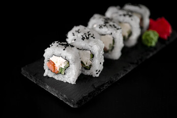 Set of rolls with tuna and cream cheese on a black background close-up