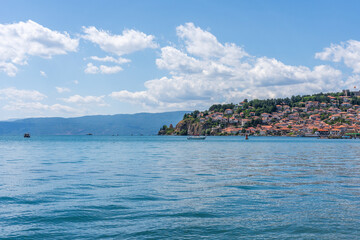 Fototapeta premium Lake Ohrid North Macedonia with the city built into the mountain in the background on a Summer day with blue sky and clouds