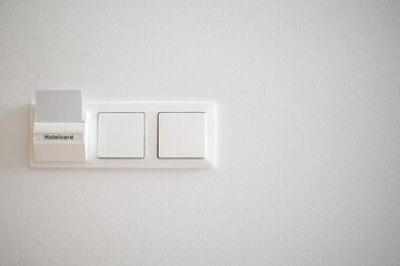 Hotelcard and switches on the background of a white wall.