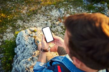 Hiker backpacker using mobile phone with empty blank screen - mockup.