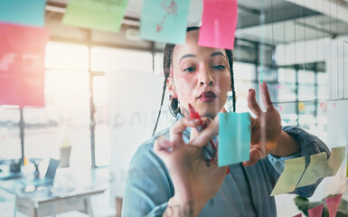 Woman at glass with ideas, thinking and sticky note for business planning, brainstorming or working...