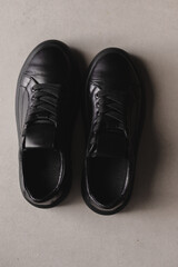 Close up details of black sneakers on the floor. Casual fashion style minimalistic shoes.