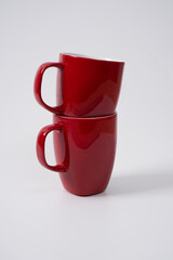 red ceramic coffee mugs on a white background