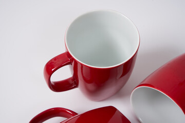 red ceramic coffee mugs on a white background