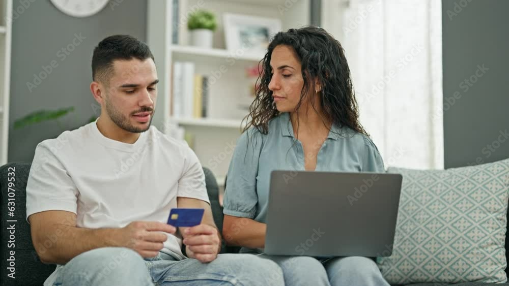 Poster Man and woman couple shopping with laptop and credit card sitting on sofa at home