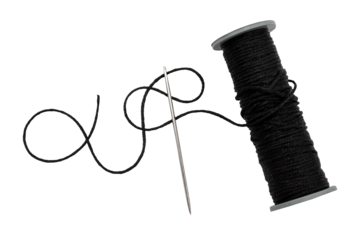 Plastic spool with black synthetic threads close-up. Needle and thread