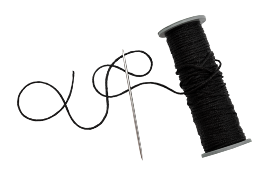 Plastic spool with black synthetic threads close-up. Needle and thread