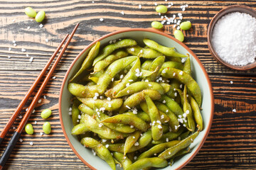 Stir-fried green Edamame Soy Beans with sea salt and sesame seeds closeup on the plate on the table. Horizontal top view from above