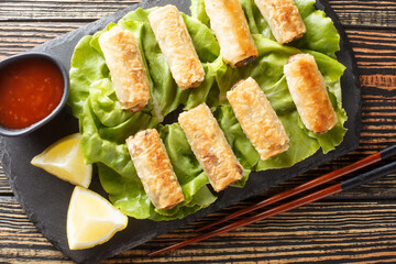 Vietnamese nems or deep fried spring rolls with chicken closeup on the plate on the table. Horizontal top view from above