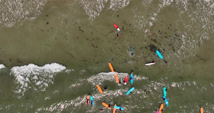Top view of the beach with surfers practising their wave 4k