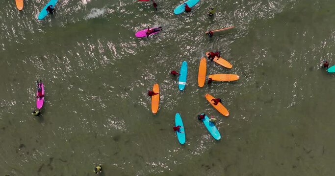 Top view of the beach with surfers practising their wave 4k