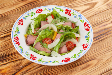 salad with ham on the wooden background