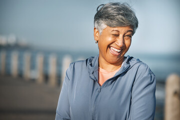 Senior, fitness and woman portrait with wink at beach happy with walking, running or morning cardio...
