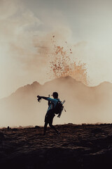 A photographer-hiker shooting with a phone under the erupting volcano in Iceland.