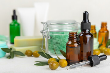 Spa olive. Composition with a jar of natural olive cream, essential oils, sea salt and natural handmade soap with olive and olive sprigs on a white background. Beauty and relax concept. Flat lay