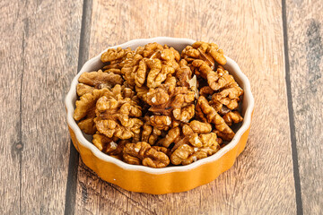 Cracked unshelled walnut in the bowl